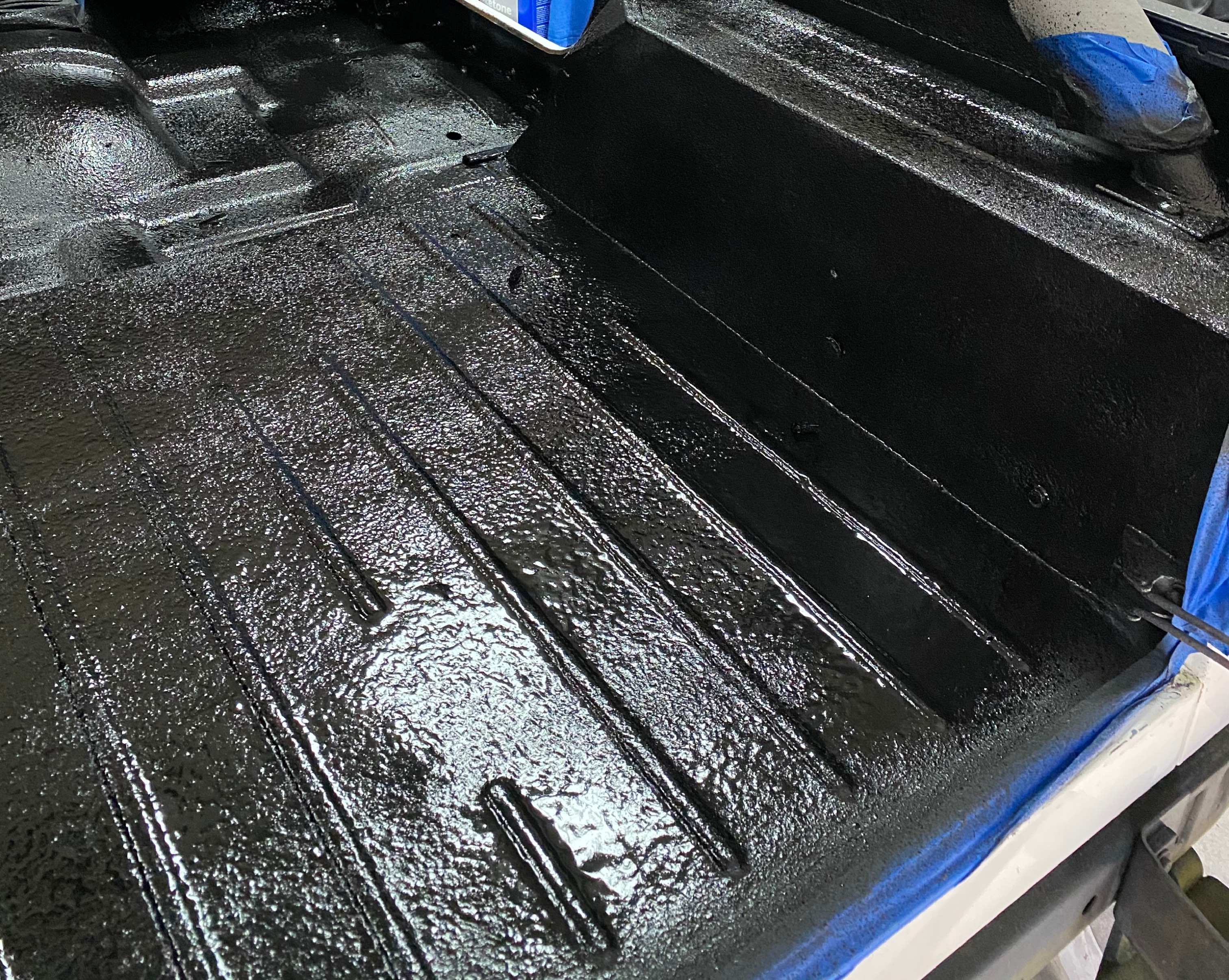 AG603X heavy-duty epoxy bed liner applied to a steel truck bed with a glossy black non-skid finish