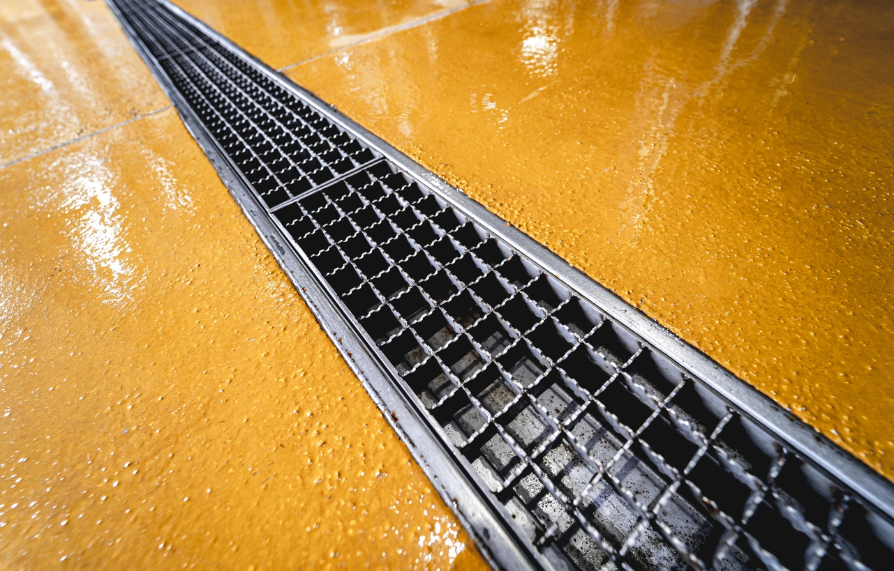 Safety yellow urethane epoxy cement around brewery trench drain &mdash; permanent non-slip finish