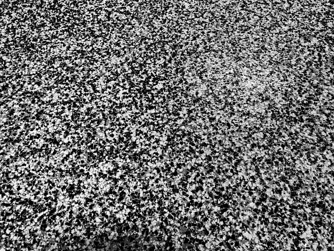 Close-up of Armor Granite flake finish showing dense 90-95% granite-look coverage